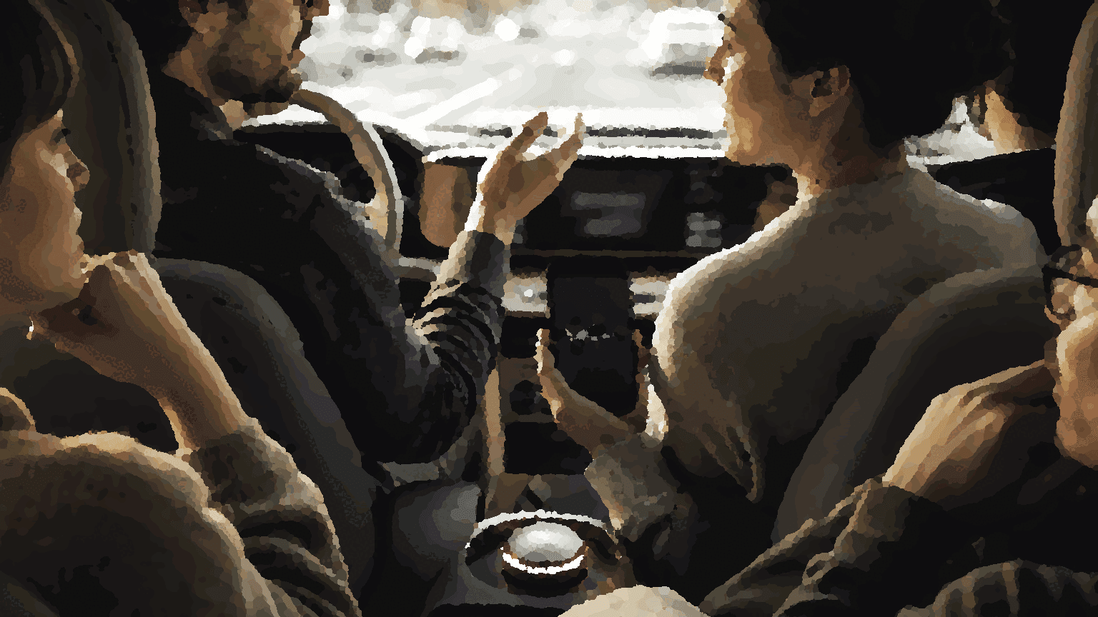 A car conversation in progress, seen from the back seat, with a shared device present but secondary to the people talking.